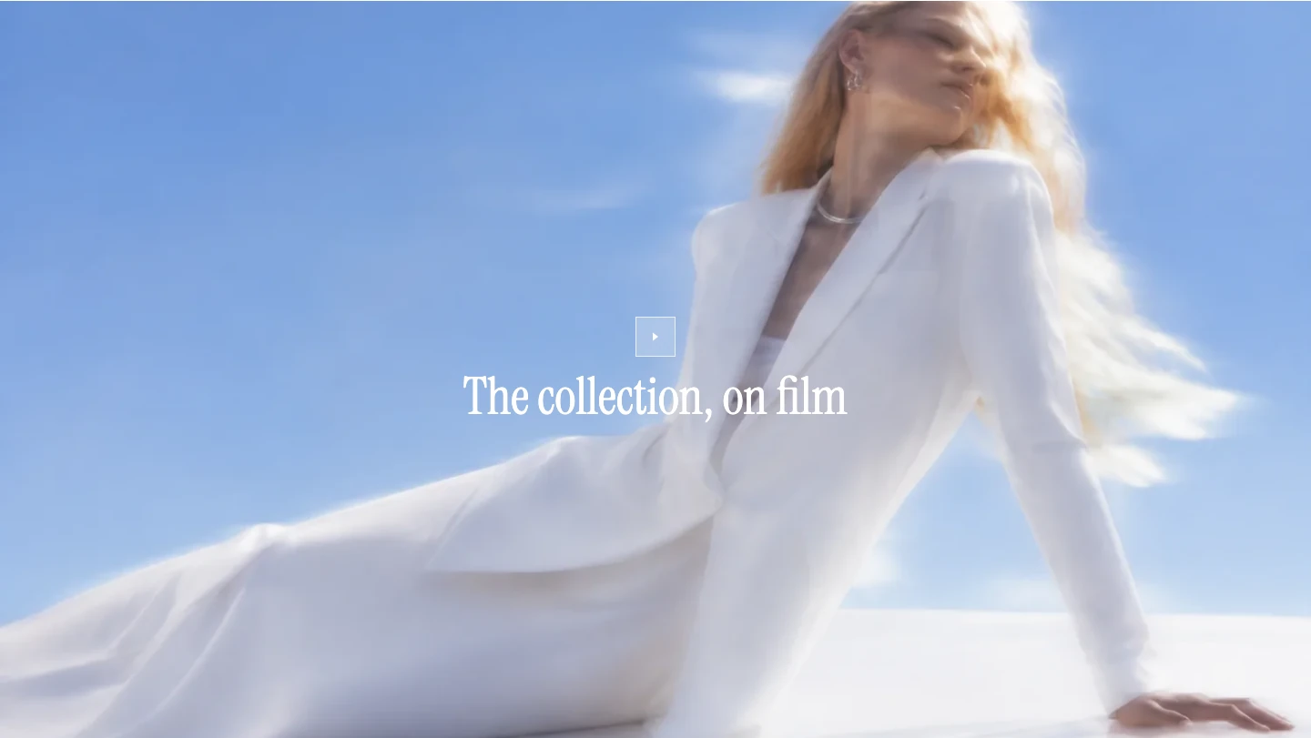 Full-width video poster of a model in white with the title The collection, on film and a small play button in the center.